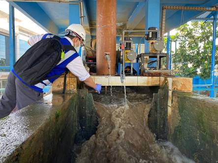 A water engineer from Perumdam Kota Depok takes water samples to test water quality parameters (pH, total dissolved solids, temperature and E.coli).