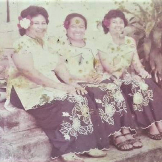 Three female WHO Samoa staff sit on a bench outside